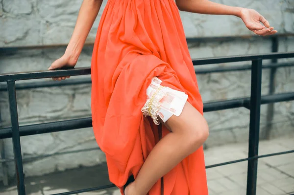Junges Mädchen Roten Kleid Beine Zeigen Geld Verdienen — Stockfoto