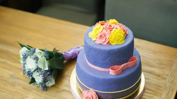 Beau gâteau de mariage avec des fleurs se tient sur une table — Photo