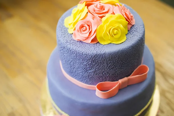 Beau gâteau de mariage avec des fleurs se tient sur une table — Photo