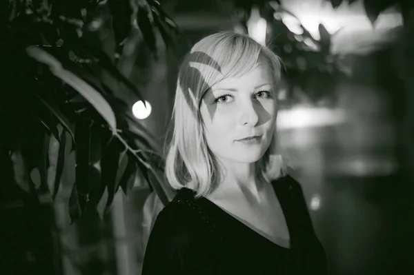 Černobílý portrét blonde v černých šatech, stín listy — Stock fotografie