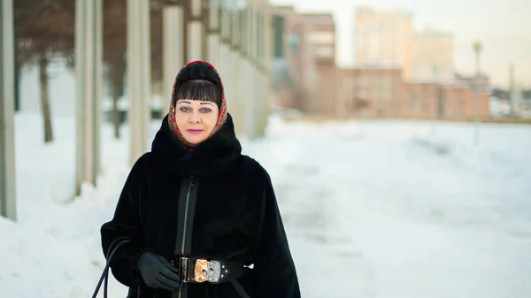 Portrait of an adult woman in warm clothing, a traditional headscarf, in the urban environment in the winter — Stock Photo, Image
