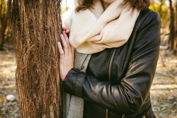 young woman walks among the trees on the bank of a sunny day