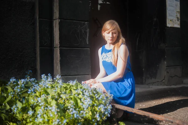 Mulher loira em um vestido azul andando ao longo da rua da cidade contra um fundo de arquitetura urbana e verão belezas siberianas — Fotografia de Stock