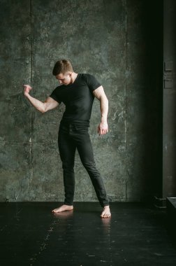 Genç seksi erkek vücut geliştirmeci atlet, stüdyo portre loft stilize duvar, adam model arka plan üzerinde