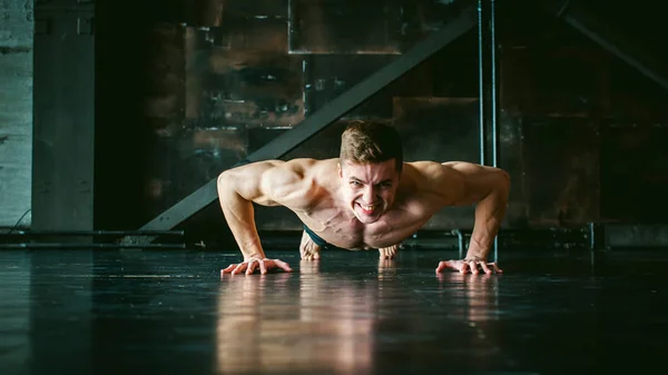 Young sexy male bodybuilder athlete with a bare torso.