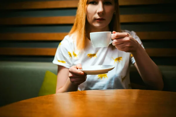 Молодая блондинка в белой футболке с печатью, ходила в кафе обедать — стоковое фото