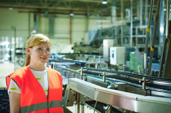 Bira ve fabrika kadın işçi. elbise, gıda üretimi, Denetim Yönetimi kontrol ekipmanları üretim için arka plan satırındaki ayakta içinde kadın portre