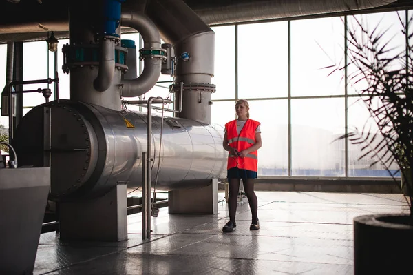 Female worker on beer factory. portrait woman in robe, standing on background line Food production, Inspection management control Equipment for production