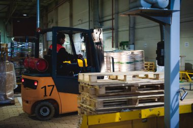 Tulum ambar çalışanı kıyafet, sürücü Reachtruck lojistik günü çalışma meşgul ile bira fıçıları fabrikasında bira üretiminin satırındaki yükleyici paletler üzerinde hareket. insan emeği imalat