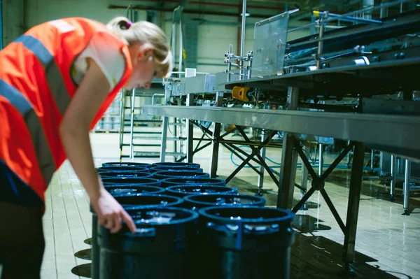 Female worker on beer factory. portrait woman in robe, standing on background line Food production, Inspection management control Equipment for production and bottling finish product end-user buyer