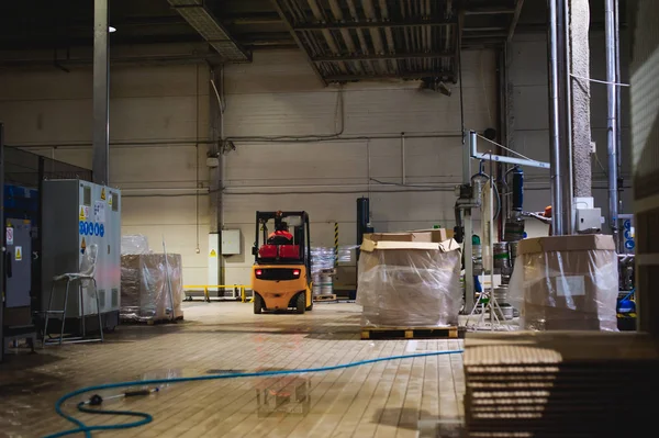 Warehouse employee in Overalls clothes, driver Reachtruck busy working on logistics Moving on loader pallets with beer kegs on line of factory for production of beer. human labor in manufacturing — Stock Photo, Image