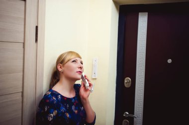 sarışın kadın İnterkom çağrıyı yanıtlar, uzun zamandır beklenen konuk varış için bekleyen onun kulağına telefonu tut. Ön kapıya yakın daire olmak