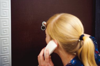 sarışın kadın İnterkom çağrıyı yanıtlar, uzun zamandır beklenen konuk varış için bekleyen onun kulağına telefonu tut. Ön kapıya yakın daire olmak