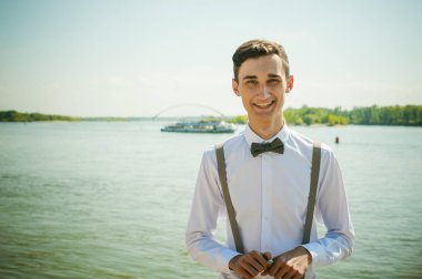 sıska genç adam, zarif şık giyinmiş beyaz gömlek, pantolon askısı ve papyon ile