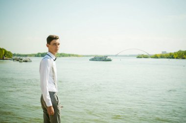 şık şık gri pantolon askısı ve papyon ile beyaz gömleği giyince giyinmiş genç sıska adam,