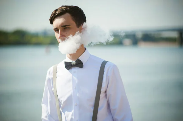 Joven flaco, elegantemente vestido con estilo en camisa blanca, pantalones con tirantes y pajarita — Foto de Stock