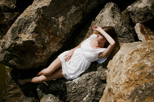 苗条的女人，在海边的石头上的肖像 — 图库照片