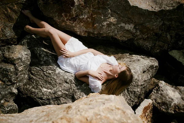 Retrato de mujer delgada sobre piedras cerca del mar —  Fotos de Stock