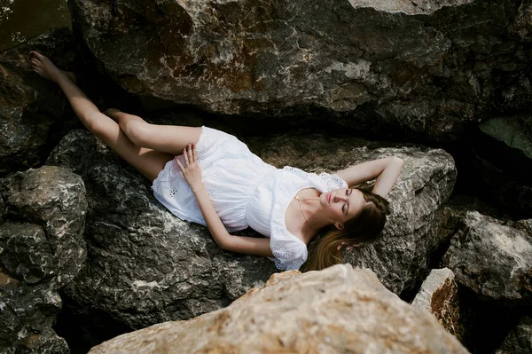 Retrato de mujer delgada sobre piedras cerca del mar —  Fotos de Stock
