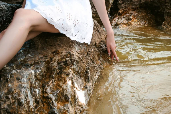 苗条的女人，在海边的石头上的肖像 — 图库照片