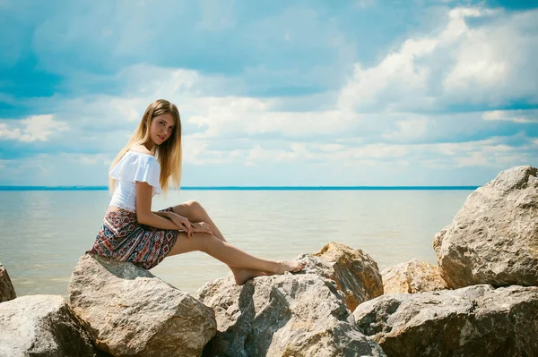 苗条的年轻女人在海边的石头上的肖像 — 图库照片