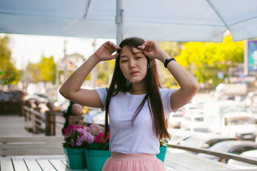 Cute asian young woman in summer cafe outdoors