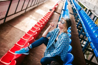 yaz gününde şafakta yola ince kadın mavi ekose desenli gömlek, kap ve kot giymiş