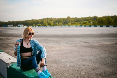 giyimli genç ince kadın mavi ekose desenli gömlek güneş gözlüğü