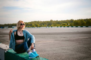 giyimli genç ince kadın mavi ekose desenli gömlek güneş gözlüğü