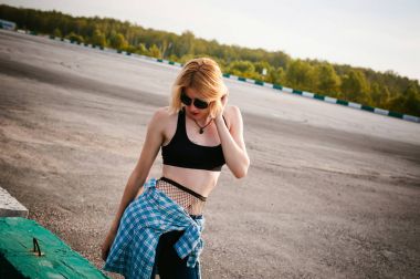 giyimli genç ince kadın mavi ekose desenli gömlek güneş gözlüğü