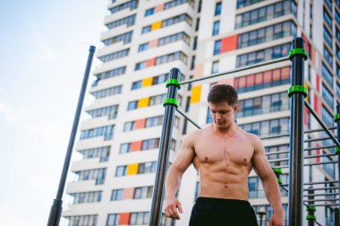 Güneşli sabah açık havada spor tesislerinde CrossFit egzersiz yapan yakışıklı seksi erkek vücut geliştirmeci atlet erkek. 