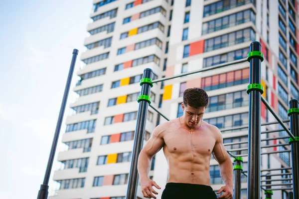 Knappe sexy mannelijke bodybuilder atleet man crossfit training in atletische faciliteiten op zonnige ochtend buitenshuis. — Stockfoto