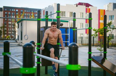 Yakışıklı seksi erkek vücut geliştirmeci atlet avluda dışında çıplak gövde ayakta olan adam. Sağlıklı yaşam konsepti.