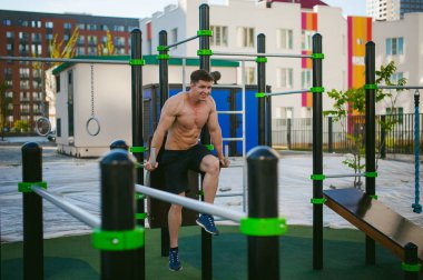 Yakışıklı seksi erkek vücut geliştirmeci atlet avluda dışında çıplak gövde ayakta olan adam. Sağlıklı yaşam konsepti.