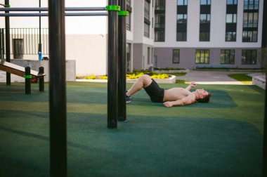 Yakışıklı seksi erkek vücut geliştirmeci atlet avluda dışında çıplak gövde ayakta olan adam. Sağlıklı yaşam konsepti.