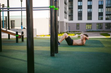 Yakışıklı seksi erkek vücut geliştirmeci atlet avluda dışında çıplak gövde ayakta olan adam. Sağlıklı yaşam konsepti.