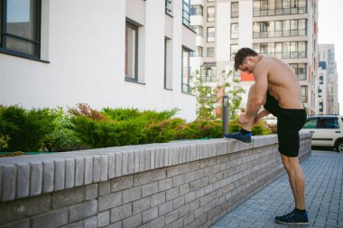 Yakışıklı seksi erkek vücut geliştirmeci atlet çıplak gövde, sabah açık havada çalışan adam. spor ayakkabı bağcıkları bağları. Sağlıklı yaşam konsepti.