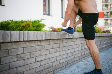 Yakışıklı seksi erkek vücut geliştirmeci atlet çıplak gövde, sabah açık havada çalışan adam. spor ayakkabı bağcıkları bağları. Sağlıklı yaşam konsepti.