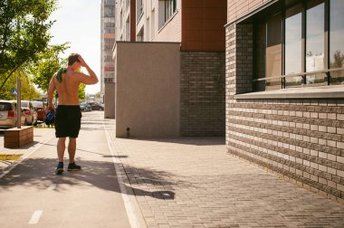 Yakışıklı seksi erkek vücut geliştirmeci sporcu adam çıplak gövde, sabah erken güneşli yaz sabahı kentsel avlular, açık havada çalışır. Sağlıklı yaşam konsepti.