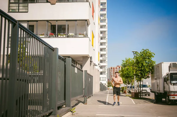 Yakışıklı seksi erkek vücut geliştirmeci sporcu adam çıplak gövde, kentsel avlularında bulunan açık hava çalıştırmak sabah ile