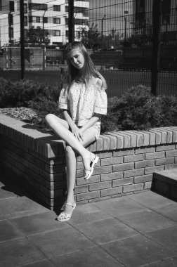 Genç güzel kadın açık havada bahçede yeşil ve evler, sıcak yaz güneşli gün zemin karşı gezinme