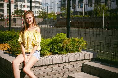 Genç güzel kadın açık havada bahçede yeşil ve evler, sıcak yaz güneşli gün zemin karşı gezinme