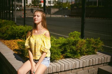 Genç güzel kadın açık havada bahçede yeşil ve evler, sıcak yaz güneşli gün zemin karşı gezinme