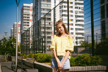 Genç güzel kadın açık havada bahçede yeşil ve evler, sıcak yaz güneşli gün zemin karşı gezinme