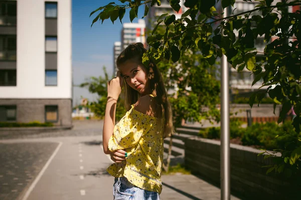 Genç güzel kadın açık havada bahçede yeşil ve evler, sıcak yaz güneşli gün zemin karşı gezinme