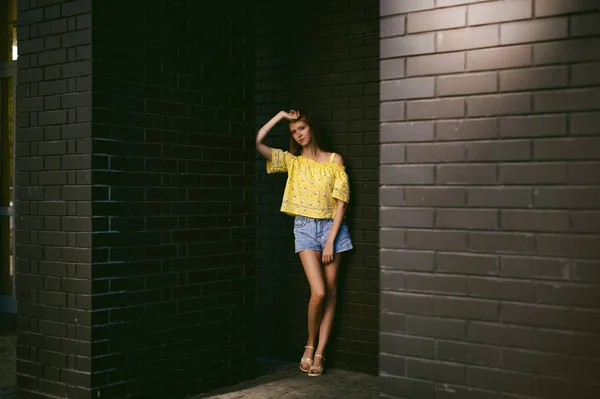 꽤 귀여운 젊은 여자 검은 벽돌의 벽에 대 한 포즈 — 스톡 사진