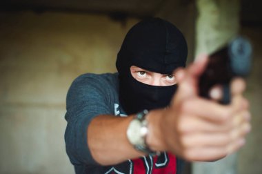 Atletik bir yün, tutar elinde tabanca bir erkekte silah ile nişan tehlikede