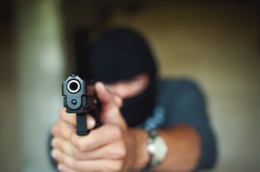Atletik bir yün, tutar elinde tabanca bir erkekte silah ile nişan tehlikede