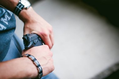 Atletik bir yün, tutar elinde tabanca bir erkekte silah ile nişan tehlikede