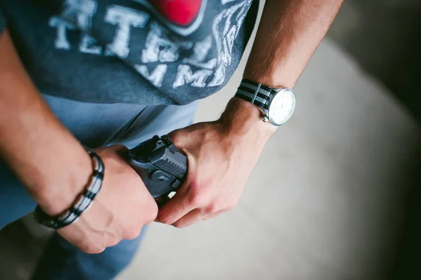 Hombre atlético en un pasamontañas, sostiene una pistola en su mano, es amenazado con disparar, apuntando — Foto de Stock